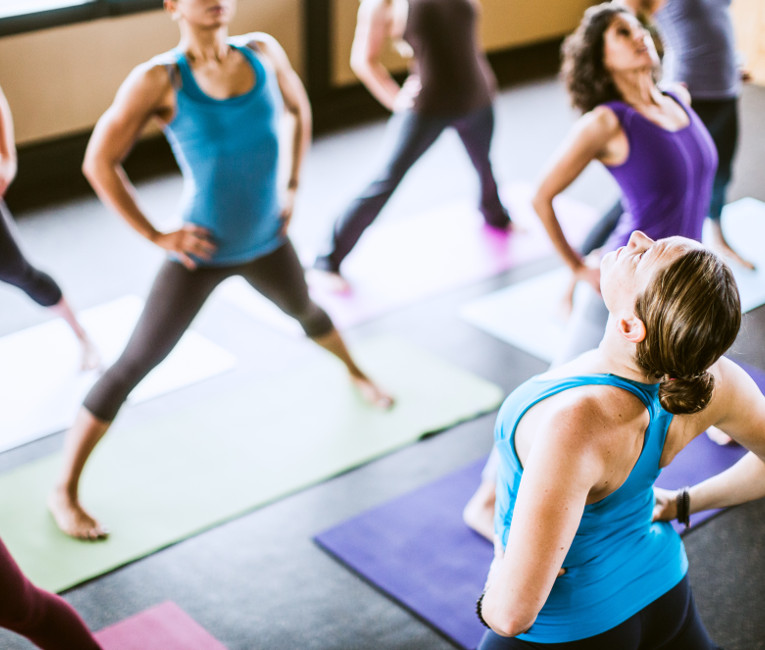 Yoga teacher teaching a class of yoga students