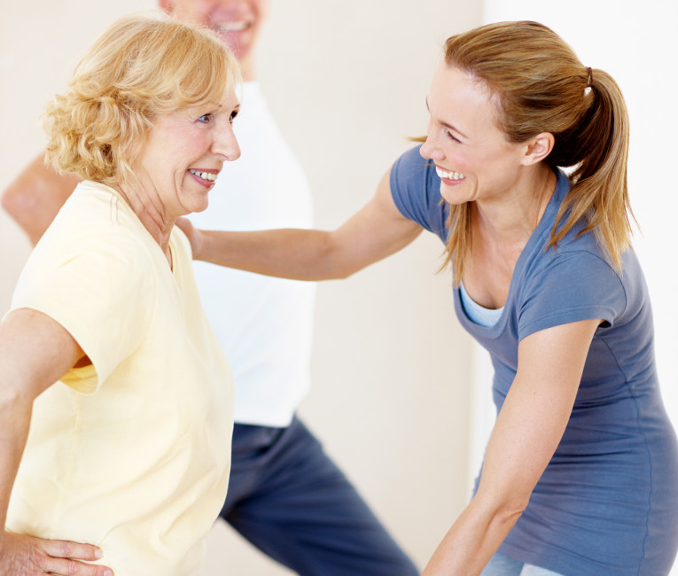 Yoga therapy trained yoga teacher assisting a student in a yoga posture